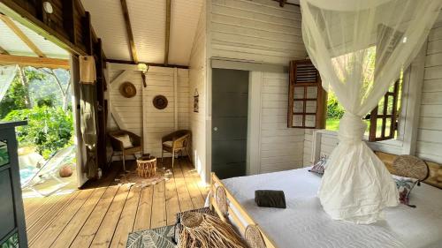 a bedroom with a bed on a wooden deck at Chalet de Dolé in Gourbeyre