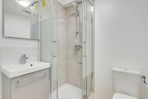 a white bathroom with a shower and a sink at Au Bord du Canal 4A *Gare*Paris*Disney* in Chelles
