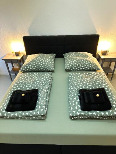 a bed with black and white pillows on it at Moderne FeWo in HDZ&Klinik Nähe in Bad Oeynhausen