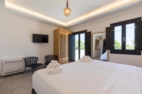 una camera con due letti e asciugamani di Nostos Apartments Kamari a Kamari