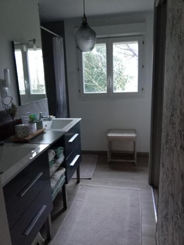 a bathroom with a sink and a large window at La Bougainvilliére in Cours