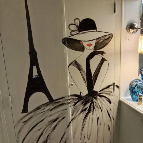 a painting of a woman in a hat and the eiffel tower at La Bougainvilliére in Cours