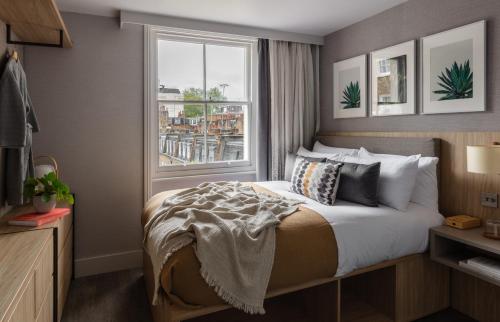 una camera d'albergo con letto e finestra di Inhabit Southwick Street, a Member of Design Hotels a Londra