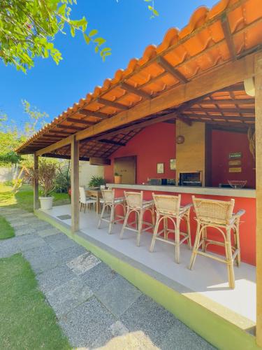 a patio with tables and chairs under a pergola at Rancho Litoral Búzios in Búzios