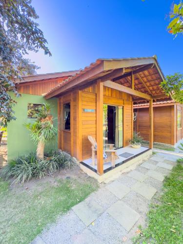 a wooden house with a bench in front of it at Rancho Litoral Búzios in Búzios
