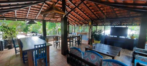 a patio with tables and chairs and a television at Residencial Recanto Ferrugem in Garopaba