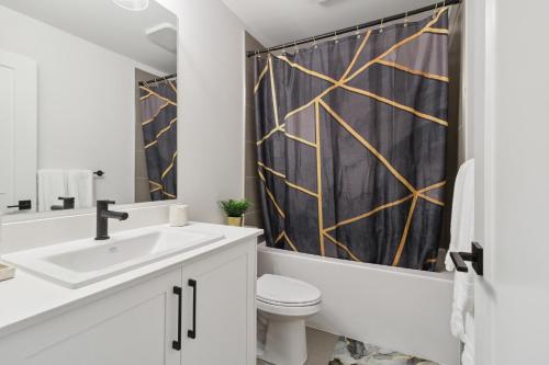 a white bathroom with a black shower curtain at Luxurious & Stylish 2BR P/Suite, Near Vancouver in Langley