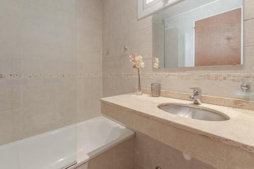 a bathroom with a sink and a mirror and a bath tub at Beautiful Apartment Downtown, Amazing Lake Views JF1 by Apartments Bariloche in San Carlos de Bariloche