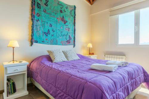 a purple bed with two pillows on it in a bedroom at Beautiful Apartment Downtown, Amazing Lake Views JF1 by Apartments Bariloche in San Carlos de Bariloche