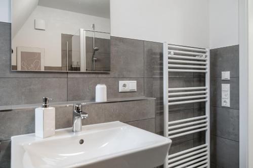 La salle de bains est pourvue d'un lavabo et d'un miroir. dans l'établissement Neubau Wohnung am Eversten Holz, à Oldenbourg
