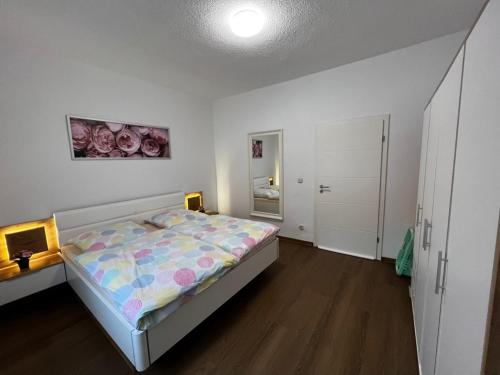 Dormitorio blanco con cama y armario en Apartment Conan, en Auerbach