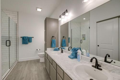 a bathroom with two sinks and a toilet and a mirror at Bright Cotter Vacation Rental with White River Views in Cotter