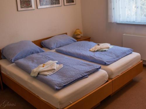 two beds in a room with blue towels on them at Hotel-Restaurant Denklinger-Hof in Reichshof 