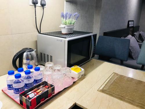 a microwave sitting on a table with bottles of water at FirIzzkey Studio in Kota Bharu