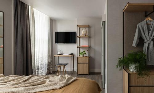 a bedroom with a bed and a television and a desk at Inhabit Southwick Street, a Member of Design Hotels in London