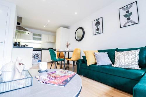 a living room with a green couch and a table at Canary Wharf-Stylish Flat-Fibre Wi-fi-10% discount in London