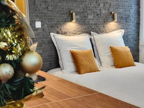 a bedroom with a bed with white pillows and a christmas tree at Studio 26 - Parking - Climatisation in Aix-en-Provence