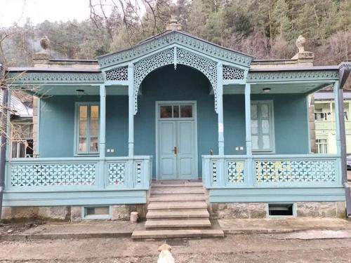 una casa azul con un gato sentado frente a ella en Home in Abastumani en Abastumani