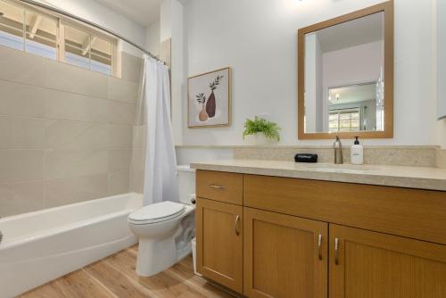 a bathroom with a toilet and a sink and a mirror at @Marbella Lane - Blissful Studio in Makaha in Waianae