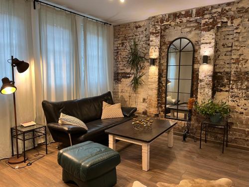 Bergisches Paradies في فرملزكيرشن: غرفة معيشة مع أريكة جلدية وطاولة