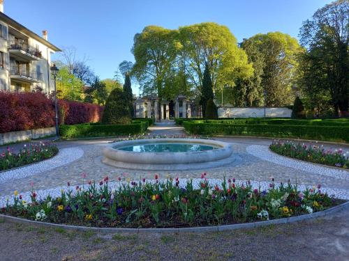 a garden with a fountain in the middle of flowers at Vivila - Al Lucernario in Cernusco sul Naviglio