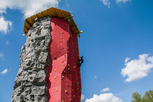 a climbing wall with people on top of it at Ramybės parkas in Sponėnai