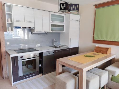 a kitchen with a table and a sink and a stove at Apartman Adna in Trnovo