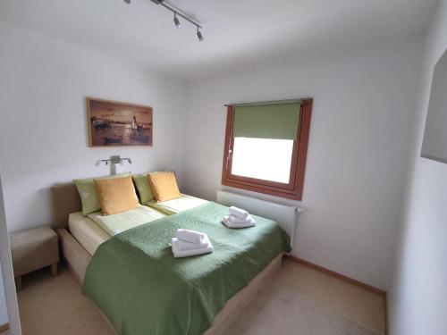 a small bedroom with a bed and a window at Apartman Adna in Trnovo
