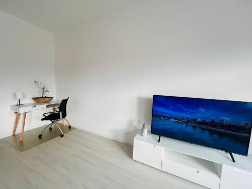 a living room with a flat screen tv on a white cabinet at Künzelsau I in Künzelsau