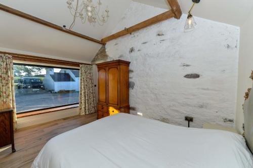 a bedroom with a white bed and a window at Bramble Cottage, hidden gem in Comber near Belfast in Ballygowan