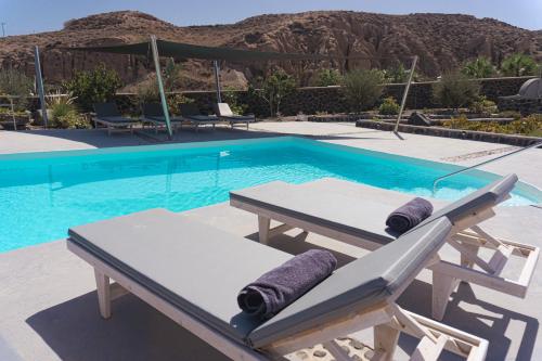a swimming pool with a picnic table next to it at Villas Scirocco in Fira