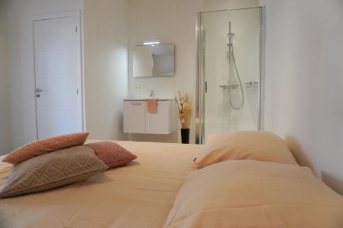 1 dormitorio con 1 cama con 2 almohadas en Casa Maris - Het huis van de zee - Viersterrenverblijf, en Nieuwpoort