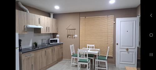 a kitchen with a table and chairs and a microwave at Apartamento NUEVO JEREZ BAHIA in Jerez de la Frontera