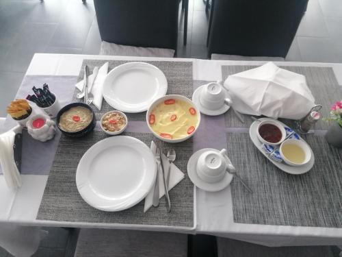 een tafel met witte borden en kommen eten bij Casa Mara in Ocna Şugatag