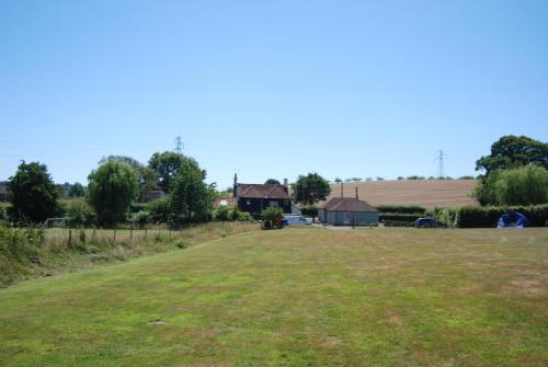 a large grass field with houses in the background at Hare & Hounds Bed & Breakfast in Rye