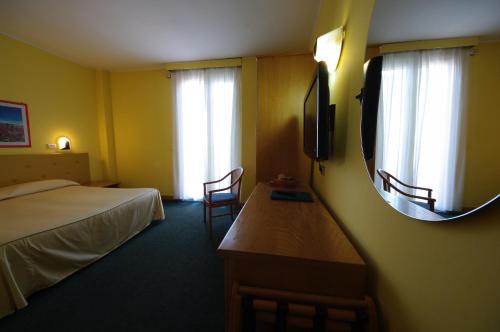 a hotel room with a bed and a mirror at Hotel Ristorante alla Campagna in San Giovanni Lupatoto