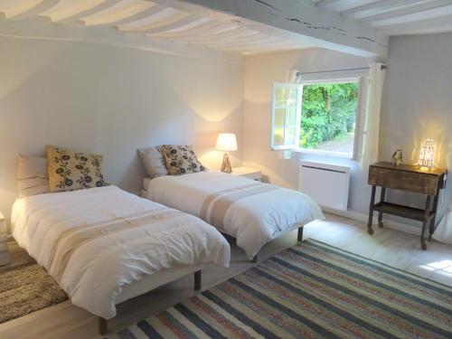 Dos camas en una habitación blanca con ventana. en Maison Saint Germain, en Varengeville-sur-Mer
