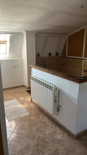 an empty kitchen with a radiator on the wall at Porriño casa céntrica in Porriño