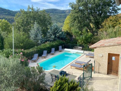 une piscine avec des chaises bleues et une maison dans l'établissement Villa Florence, à Alet-les-Bains