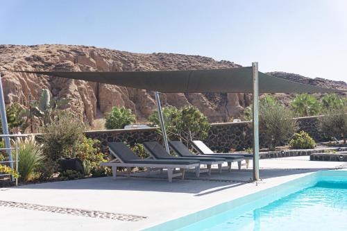 a group of lounge chairs next to a swimming pool at Villas Scirocco in Fira