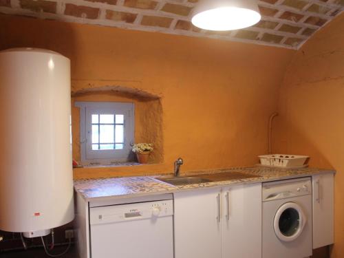 uma cozinha com um lavatório e uma janela em Can Perot em Romanyá de la Selva