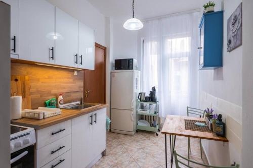 a kitchen with a white refrigerator and a table at Spacious 3BD Central apartment in Sofia