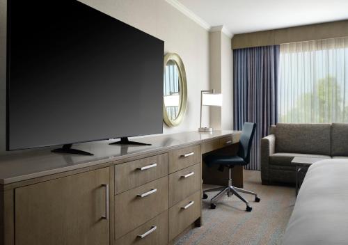 a hotel room with a large flat screen tv on a desk at DoubleTree by Hilton Irvine Spectrum in Irvine