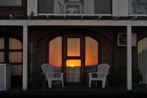 two white chairs sitting in front of a building at Carilo Soleil By HS in Carilo