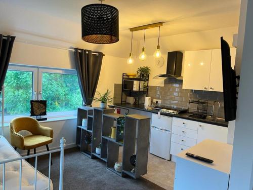 a kitchen with white cabinets and a chair in a room at PRESTON ROOM LET 8 in Yeovil