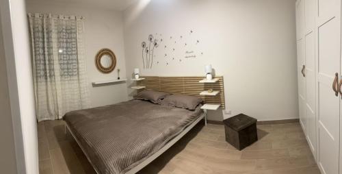 een slaapkamer met een bed met een houten hoofdeinde bij Casa Butera Sicily in Bagheria