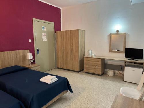 Schlafzimmer mit einem Bett und einem Schreibtisch mit einem Computer in der Unterkunft Roma Hotel in Sliema