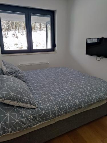 Cama en habitación con ventana en Apartman Virgin Forest - FREE Garage Bjelašnica en Bjelašnica