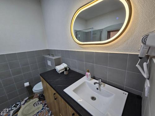 bagno con lavandino e specchio di Cozy Luxury Apartments - City Center #Targu Mures a Târgu-Mureş