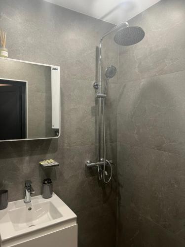 ein Bad mit einer Dusche und einem Waschbecken in der Unterkunft Апартамент за гости Генови in Vratsa